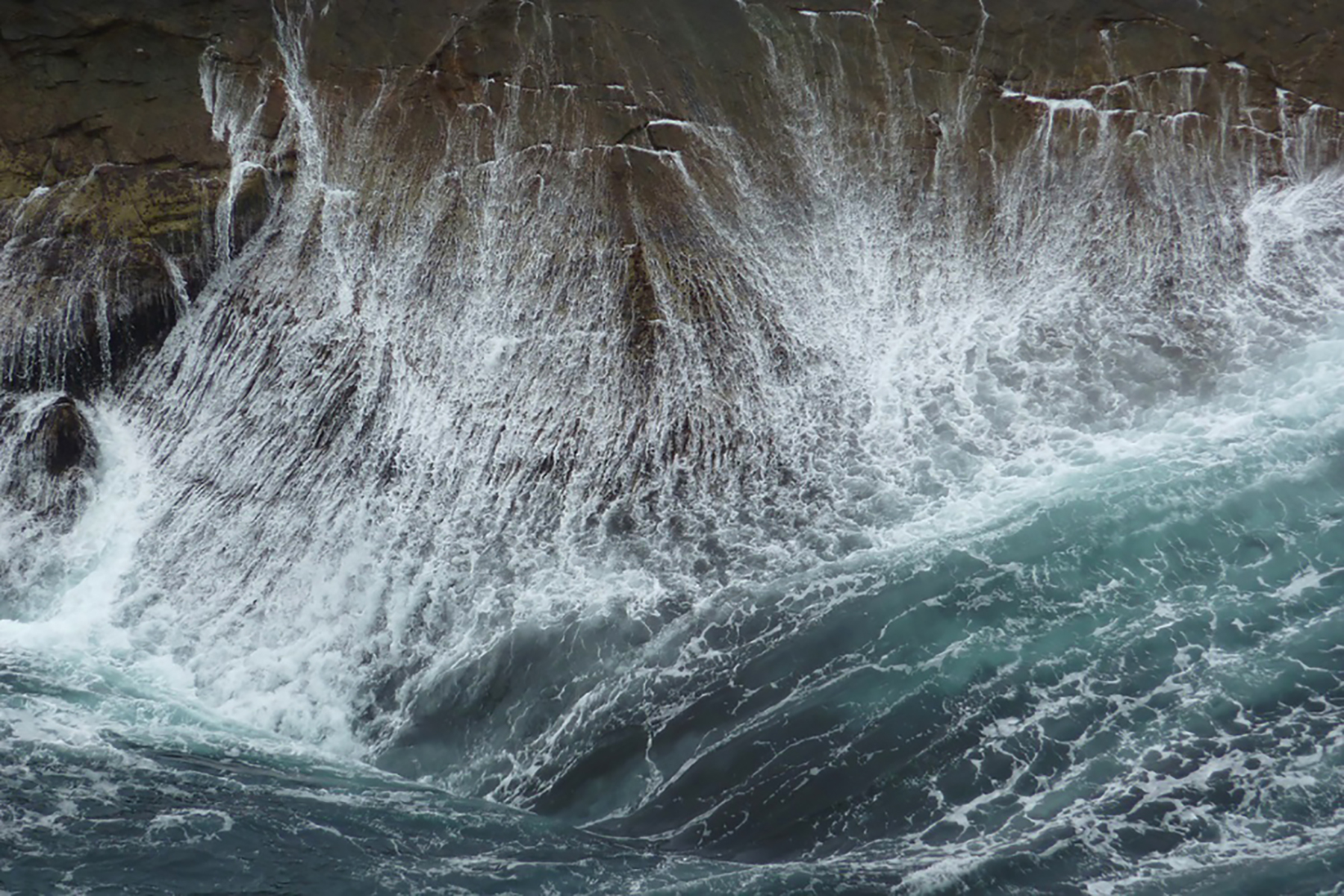 waves surging against a rocky cliff