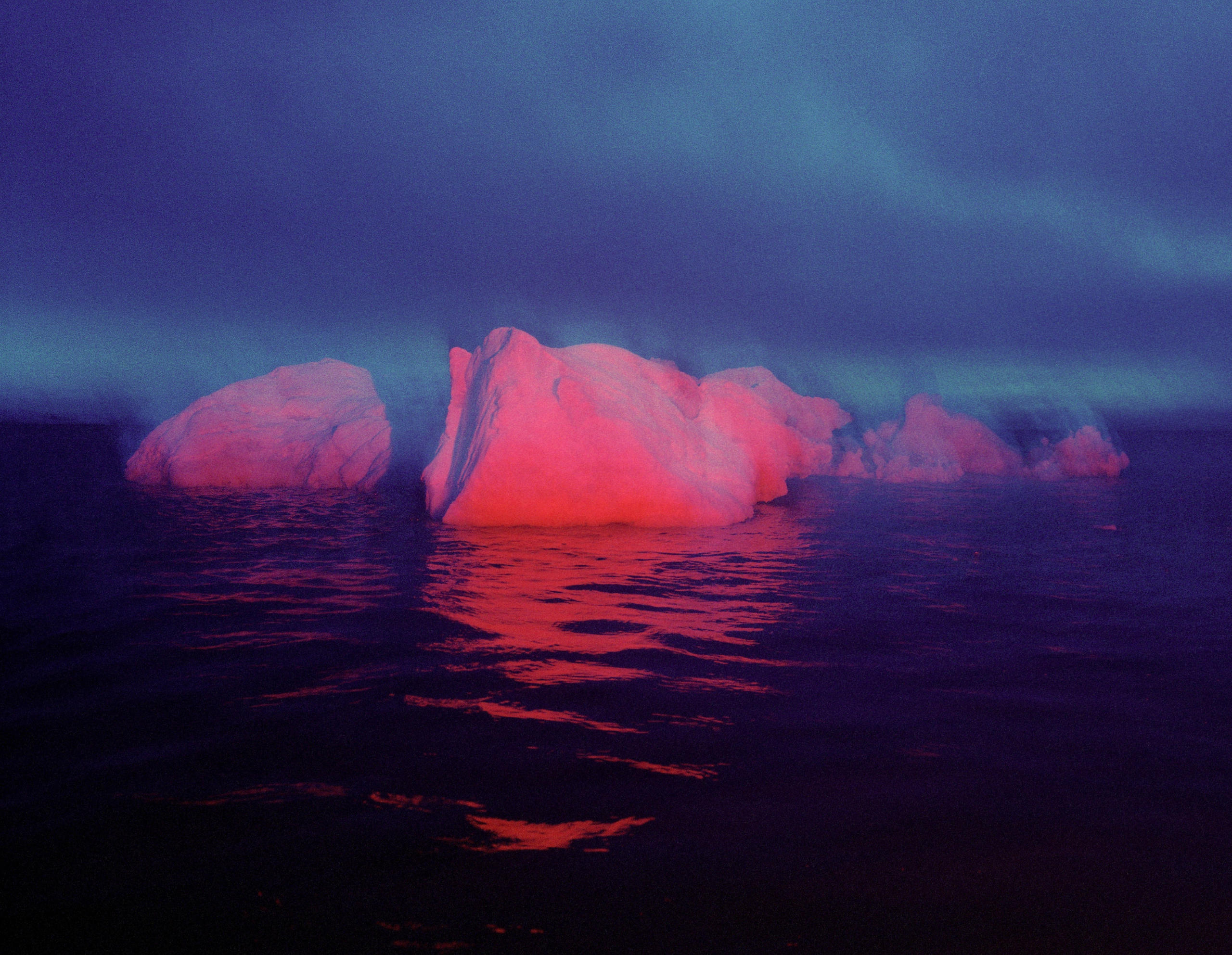 iceberg spotlit by red light