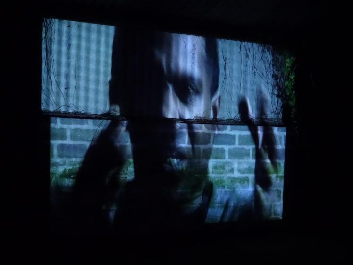 fragmented projection of a man on an urban wall