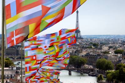 international flags in front of a Paris cityscape