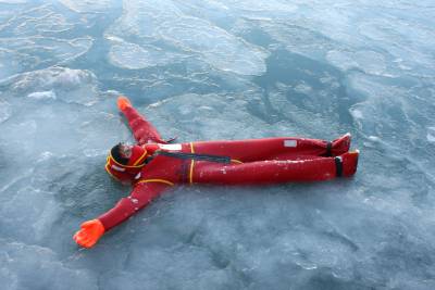 man in a survival suit floats in Arctic water